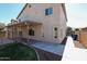 Exterior view of the home featuring a covered patio and landscaped yard at 17474 W Acapulco Ln, Surprise, AZ 85388