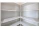 Walk-in pantry featuring built-in white shelves for storage at 17474 W Acapulco Ln, Surprise, AZ 85388