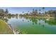 Beautiful pond view with lush green grass, rocks, trees and reflections of homes in the water at 1966 E Drake Dr, Tempe, AZ 85283