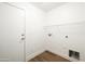 A minimalist laundry room with wood-look floors, wire shelving, and hookups for a washer and dryer at 22610 N 17Th St, Phoenix, AZ 85024