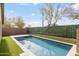 Backyard featuring a rectangular pool, travertine decking, artificial grass, and privacy landscaping at 22610 N 17Th St, Phoenix, AZ 85024