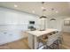 Well-lit kitchen featuring white cabinets, stainless steel appliances, a large island with counter seating at 22864 E Via Del Sol --, Queen Creek, AZ 85142