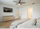 Bright main bedroom featuring a ceiling fan, wood floors, and a large tv mounted above the wooden dresser at 22864 E Via Del Sol --, Queen Creek, AZ 85142