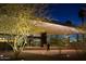 Modern building exterior at night with a flat roof, lit trees, and people entering the front doors at 2302 N Central Ave # 412, Phoenix, AZ 85004