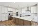 Bright, modern kitchen features stainless steel appliances, white cabinets, and island with sink at 26029 N 23Rd Ave, Phoenix, AZ 85085