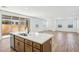 Kitchen island with sink overlooks open floor plan living and dining area with access to patio at 26029 N 23Rd Ave, Phoenix, AZ 85085