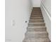 Carpeted staircase with white walls and railings leads to the upper level of the home at 26029 N 23Rd Ave, Phoenix, AZ 85085