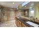 Spacious bathroom featuring dual sinks with granite countertops, travertine tile, a large mirror, and a separate shower at 2637 E Beekman Pl, Phoenix, AZ 85016