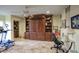 Bonus room with built-in shelving and cabinets with an elliptical machine and desk, great for work and play at 2637 E Beekman Pl, Phoenix, AZ 85016