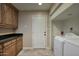 Well-equipped laundry room featuring front load washer/dryer, storage cabinets, and access to the exterior at 2637 E Beekman Pl, Phoenix, AZ 85016