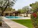 Community pool surrounded by mature trees, greenery, and a clubhouse at 2637 E Beekman Pl, Phoenix, AZ 85016