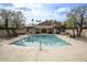 Community pool with clear blue water surrounded by trees and a clubhouse at 2637 E Beekman Pl, Phoenix, AZ 85016