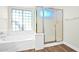 Bright bathroom features soaking tub and a glass-enclosed shower, next to a frosted glass window at 3037 S Coyote Cyn, Mesa, AZ 85212