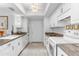 Galley kitchen featuring white cabinets, granite countertops, and modern appliances at 3038 E Marlette Ave, Phoenix, AZ 85016