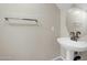 Powder room featuring a pedestal sink with chrome fixtures, neutral walls, and a round mirror at 34916 N 31St Ave, Phoenix, AZ 85086