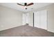 Bedroom featuring neutral walls, carpet, ceiling fan, and a closet with white sliding doors at 34916 N 31St Ave, Phoenix, AZ 85086