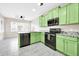 Stylish kitchen with green cabinets, black appliances, granite countertops, and modern tile flooring at 34916 N 31St Ave, Phoenix, AZ 85086