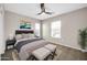 Main bedroom featuring neutral walls, carpet, ceiling fan, and a king size bed with plush bedding at 34916 N 31St Ave, Phoenix, AZ 85086