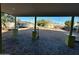 A covered back patio looks out on a large yard with mature trees and a paver patio at 4002 N 58Th Dr, Phoenix, AZ 85031