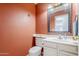 Cozy powder room featuring a modern vanity, decorative mirror, and warm, inviting wall color at 4033 E Wildcat Dr, Cave Creek, AZ 85331