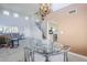 View of the dining area featuring modern chandelier, glass-top table with metal chairs, and access to the kitchen and living room at 4033 E Wildcat Dr, Cave Creek, AZ 85331