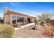 Backyard view featuring a covered patio, lounge chairs, well-kept desert landscape and greenery at 41802 N Bridlewood Way, Anthem, AZ 85086