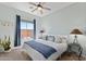 Bright bedroom with a queen bed, ceiling fan and natural light from the window at 41802 N Bridlewood Way, Anthem, AZ 85086