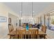 Open-concept dining room with rustic wood table and chairs, pendant lights, and views into the living area at 41802 N Bridlewood Way, Anthem, AZ 85086