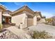 Modern home's exterior showcasing a large two-car garage, a well-maintained walkway, and desert landscaping at 41802 N Bridlewood Way, Anthem, AZ 85086