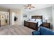 Bedroom with rustic wood bed frame, ceiling fan, and views of the en suite bathroom at 41802 N Bridlewood Way, Anthem, AZ 85086