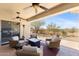 Covered outdoor patio with wicker furniture, a ceiling fan, and desert views at 41802 N Bridlewood Way, Anthem, AZ 85086