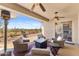 Covered patio with stylish seating arrangement, ceiling fans, and scenic views, perfect for outdoor gatherings at 41802 N Bridlewood Way, Anthem, AZ 85086