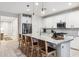 Kitchen featuring white cabinets, quartz countertops, stainless steel appliances, and seating at the large island at 5428 N 188Th Ln, Litchfield Park, AZ 85340