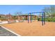 Community playground featuring swings, benches, and a covered picnic area on a rubber mulch surface at 5428 N 188Th Ln, Litchfield Park, AZ 85340