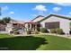 Beautifully landscaped backyard with patio dining set, artificial grass and an outdoor fireplace at 5439 N Ormondo Way, Litchfield Park, AZ 85340