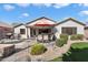 Home's backyard featuring a covered patio, dining set, built-in barbecue, outdoor fireplace and mature landscaping at 5439 N Ormondo Way, Litchfield Park, AZ 85340