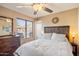 Bedroom with ceiling fan, wooden headboard, dresser, and a bright, airy feel at 5439 N Ormondo Way, Litchfield Park, AZ 85340