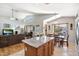 Open-concept kitchen and dining area with vaulted ceiling and views into living room at 5439 N Ormondo Way, Litchfield Park, AZ 85340