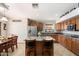 Bright kitchen with custom wood cabinets, granite countertops, and stainless steel appliances at 5439 N Ormondo Way, Litchfield Park, AZ 85340