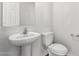 A clean half-bathroom featuring a pedestal sink and toilet at 5462 W Fulton St, Phoenix, AZ 85043