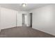 A bedroom with white walls and neutral carpeting and two open doors at 5462 W Fulton St, Phoenix, AZ 85043