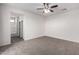 Carpeted bedroom features a ceiling fan and view to the bathroom with shower and tub at 5462 W Fulton St, Phoenix, AZ 85043