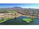 Scenic aerial view of the golf course and surrounding community, with a pond and mountain backdrop at 6271 S Twilight Ct, Gilbert, AZ 85298