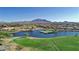 Scenic golf course aerial view with a large lake, lush fairways, and mountain views at 6271 S Twilight Ct, Gilbert, AZ 85298