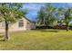 Expansive grassy backyard with mature trees and a neutral colored stucco house at 6271 S Twilight Ct, Gilbert, AZ 85298