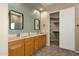 Bathroom featuring a double vanity, mirrors, wood-look tiling, and closet access at 6271 S Twilight Ct, Gilbert, AZ 85298