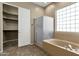 Modern bathroom featuring a tub, shower, and access to a walk-in closet at 6271 S Twilight Ct, Gilbert, AZ 85298