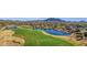 Scenic aerial view of a golf course with lush green fairways, a lake, and mountain views at 6271 S Twilight Ct, Gilbert, AZ 85298