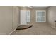 Bright, carpeted living room with plantation shutters and a distinctive tile accent at the entryway at 6271 S Twilight Ct, Gilbert, AZ 85298