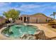 Backyard pool surrounded by rocks with covered patio and stucco house in background at 6271 S Twilight Ct, Gilbert, AZ 85298